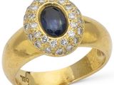 gros plan d'une bague en or avec un saphir et des diamants