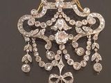 a close up of a diamond and gold necklace on a black surface