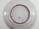 a white plate with a brown rim sitting on a table