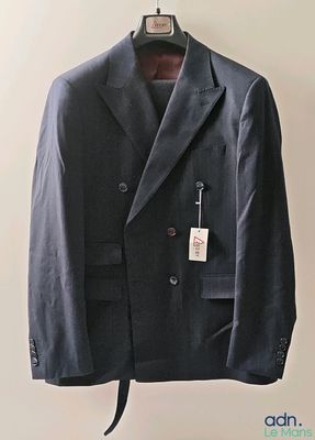 a suit hanging on a hanger on a wall
