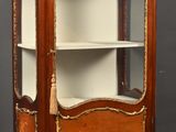 une vitrine ancienne en bois, dotée d'une porte vitrée et d'étagères