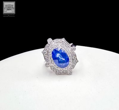 a close up of a ring with a blue stone surrounded by diamonds
