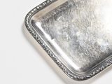 a silver tray on a white table with a silver handle