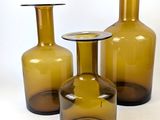 three brown glass vases sitting next to each other on a white surface