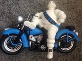 une figurine représentant un homme assis sur une moto bleue