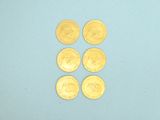 four gold coins are arranged in a row on a blue surface