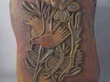 sculpture of a bird on a branch with leaves on a wooden base