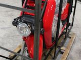 un scooter rouge garé à l'intérieur d'une cage métallique