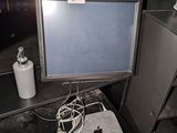 an apple computer sitting on top of a desk next to a trash can