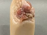 a small sculpture of a fish on a block of soap