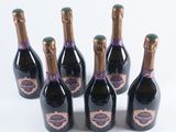 six bottles of champagne are lined up on a white surface