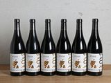 six bouteilles de vin sont alignées sur une table en bois