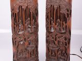 paire de lampes asiatiques en bois sculpté posées sur un support blanc