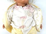 a baby doll that is laying down on a white surface