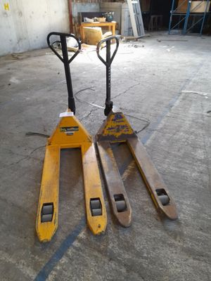 two forklifts that are sitting in a warehouse