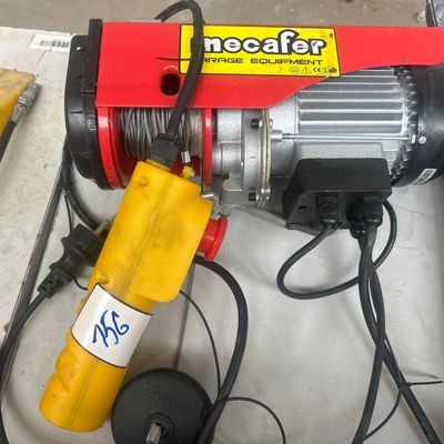 un palan électrique rouge et jaune posé sur une table