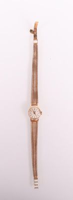 a gold watch on a white surface with a white background