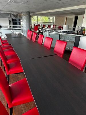 une longue table avec des chaises rouges au milieu de la pièce