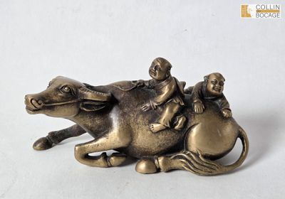 a figurine of a man riding a horse with two children on it