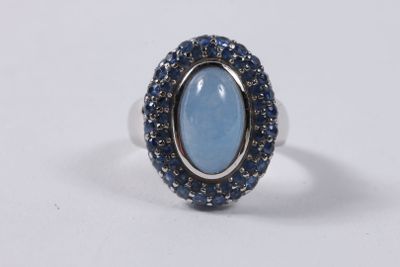 une bague ornée d'une pierre bleue entourée de saphirs bleus