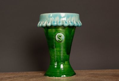 un vase vert posé sur une table
