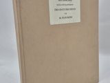 an old book sitting on a white surface with a label on it