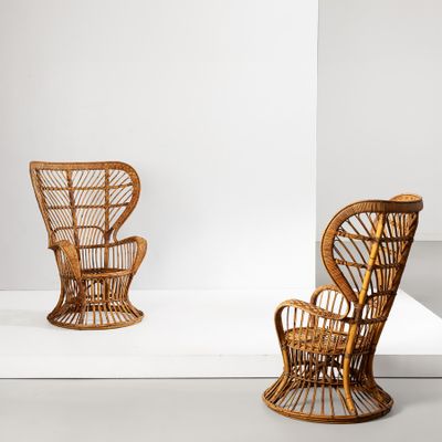 une paire de chaises en osier dans une pièce blanche, avec un fond blanc en arrière-plan