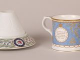 a cup and saucer sitting next to each other on a table