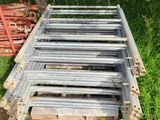 a pile of metal bars sitting in the grass next to a tree