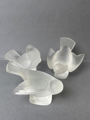 pair of clear glass fish figurines on a gray surface