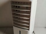 a small air conditioner sitting on the floor next to a wall