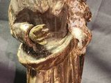 an old statue of a woman holding a flower in her hands