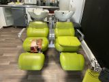 four green chairs in a room with a sink and a mirror