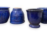 three blue vases are sitting next to each other on a white surface