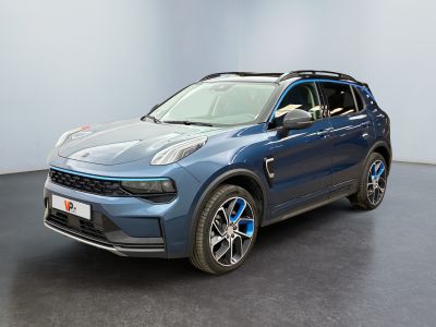 Le SUV bleu est garé dans une grande pièce au sol noir.