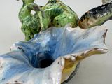 a blue and green vase with two animals in it