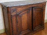 une armoire en bois avec un plateau en marbre, posée sur un parquet