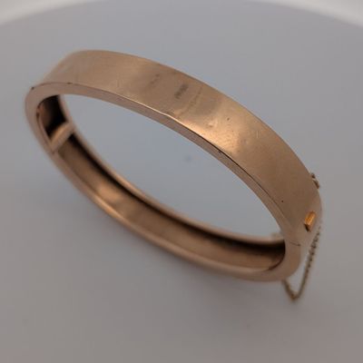 gros plan d'une bague en or sur une surface blanche