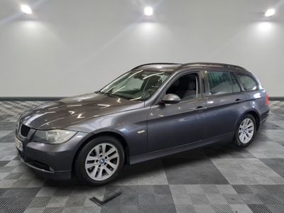 Une BMW Série 3 Touring de 2011 exposée dans un showroom au sol à damier