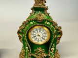 a green and gold clock sitting on a table