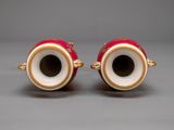 pair of red and gold vases on a gray surface