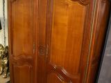 a large wooden armoire in the corner of a room