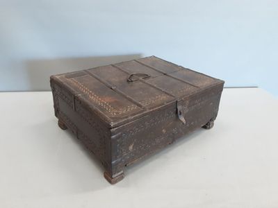 une vieille boîte en bois posée sur une table blanche