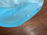 a blue glass bowl with water in it sitting on a table