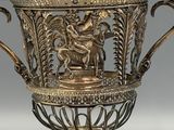 an antique silver plated cup on a stand with a lion on it
