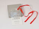 a picture of a glass ornament with a red ribbon
