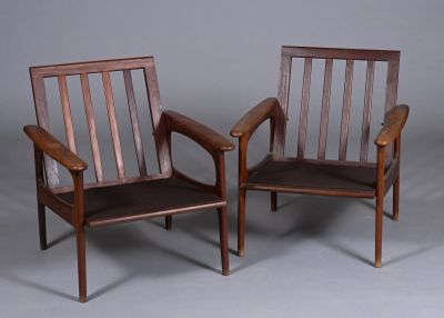 une paire de chaises en bois avec accoudoirs et pieds, sur fond gris