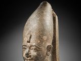 a stone head of an egyptian woman