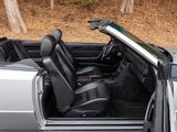 a silver convertible car with its doors open in a wooded area