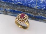 gros plan d'une bague en or avec un rubis et un diamant au centre